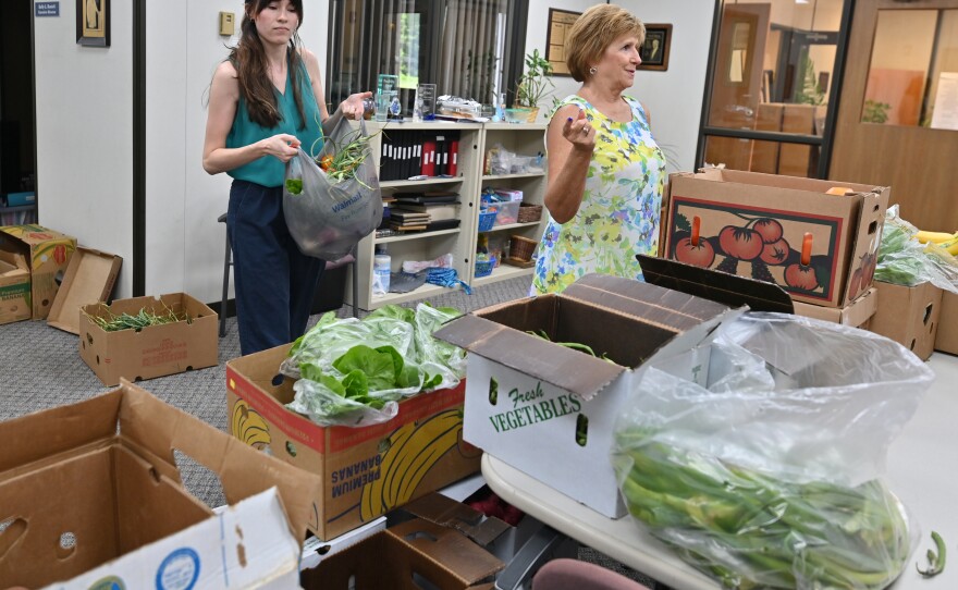 Elsa Romero and Darcie Schaffer package bags of fresh fruits and vegetables from Food Dignity.