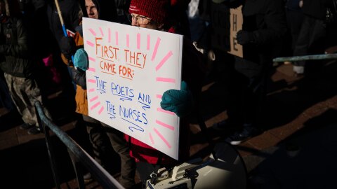 Lisa Nee, originally from Minneapolis, holds up a sign that references the deaths of Renee Good and Alex Pretti in the form of the famous poem, “First They Came”.