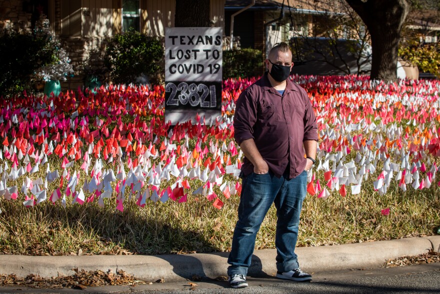 Shane Reilly frente a su casa en Brentwood, donde ha plantado banderillas por cada tejano muerto por COVID-19.