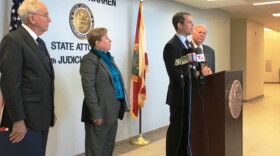 State Attorney Andrew Warren, at microphone, with retired Judge E.J. Salcines, right; Chris Alternbernd, left, and Teresa Hall
