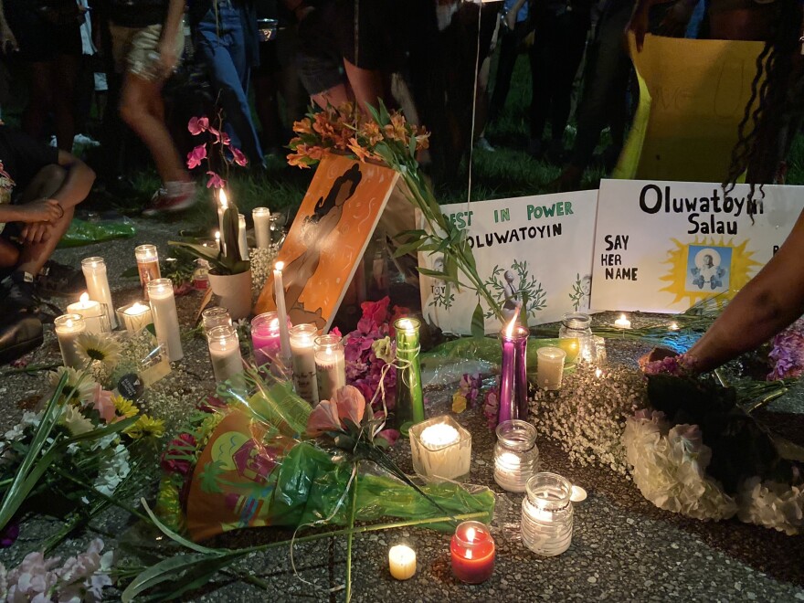 Friends place candles, flowers, and signs down in honor of Oluwatoyin Salau, a 19-year-old woman found dead in Tallahassee, Fl.