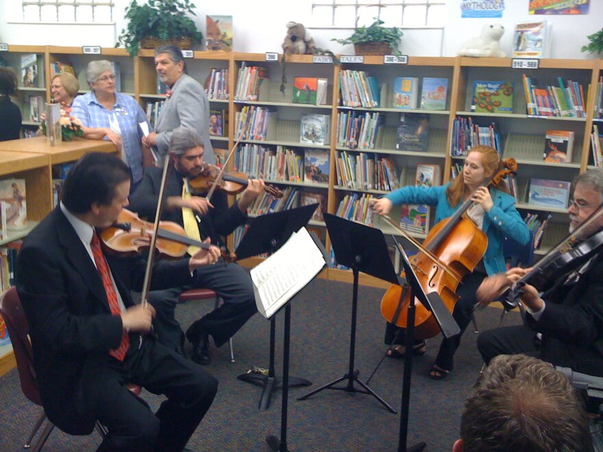 The Signature Symphony's string quartet performs at the Eugene Fields Elementary School in West Tulsa as the Mentoring to Music program is announced.