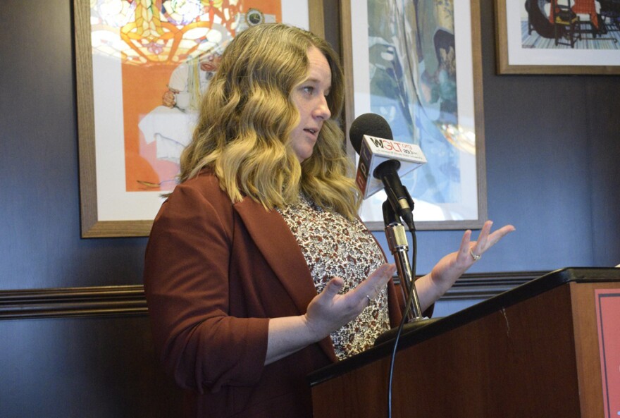 A woman speaks at a podium during a press conference