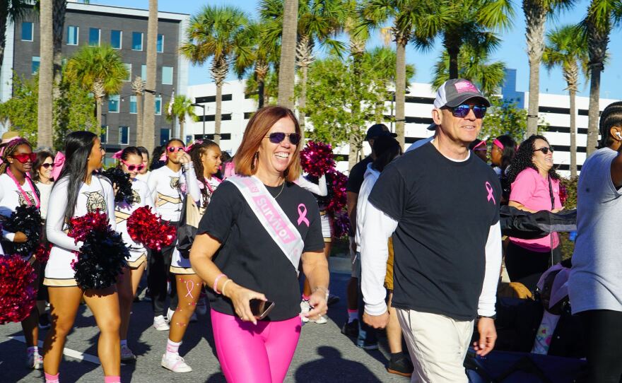 Heather Starling, center, was diagnosed with breast cancer in January 2021 and is now four years in remission. She encouraged others facing breast cancer to keep pushing. “Fight, fight like hell,” she told participants of the Making Strides for Breast Cancer walk on Saturday, Oct. 25, 2025. (Krystal Felix/WUFT News)