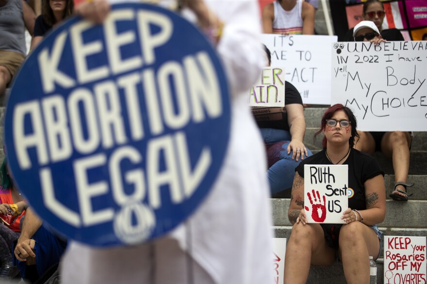 FILE - Protesters hold signs as Barbara DeVane, of the Tallahassee National Organization for Women, speaks outside the Florida Historic Capitol, June 24, 2022, in Tallahassee, Fla., during a rally protesting the Supreme Court's overturning of Roe v. Wade. The Florida Supreme Court issued rulings Monday, April 1, 2024, allowing the state's voters to decide whether to protect abortion rights and legalize recreational use of marijuana, rejecting the state attorney general's arguments that the measures should be kept off the November ballot. (Chasity Maynard/Tallahassee Democrat via AP, File)