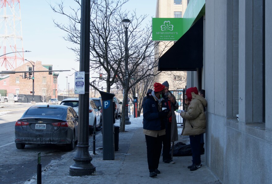 People staying at the downtown safe haven shelter in St. Patrick Center take a smoke break on Friday morning.