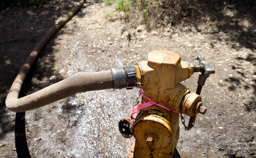 water sprays out of a yellow fire hydrant 