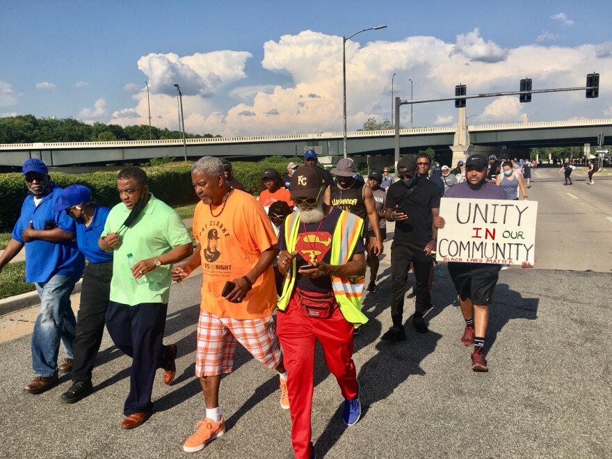 Activist Pat Clarke (in orange) spoke at a rally organized by the anti-violence group Aim 4 Peace.