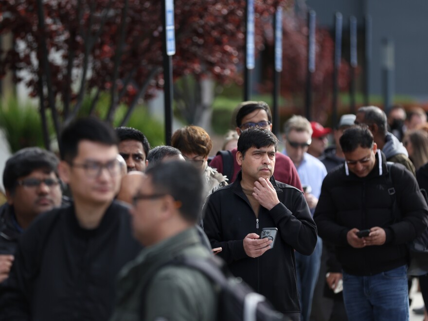 People line up outside of a Silicon Valley Bank office in Santa Clara, Calif., on March 13, 2023. in Santa Clara, California. Depositors lined up to retrieve their money even after after regulators rescued the tech-focused lender.