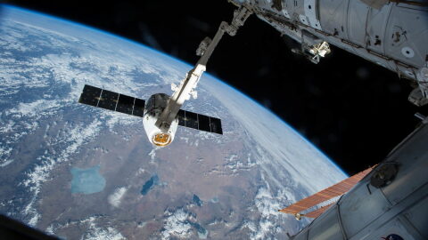 FILE - In this Friday, April 17, 2015 file photo, the Canadarm 2 reaches out to capture the SpaceX Dragon cargo spacecraft for docking to the International Space Station. Americans haven't rocketed into orbit from their home turf since NASA's last shuttle flight in 2011. SpaceX and Boeing expect to resume human launches from Cape Canaveral in another year or two. (AP Photo/NASA)