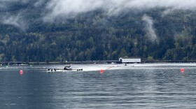 An eight-person boat crosses the finish line at a Dexter Lake regatta in April 2026.