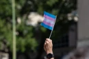 An attendee waves a trans pride flag while marching with activists and supporters from the Bexar County Courthouse to Crockett Park in “March for Us,” San Antonio's third annual celebration of Transgender Day of Visibility, on March 29, 2025 in San Antonio.