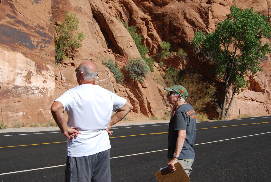 Smith (right) answers questions for a tourist about the petroglyph panels along the Colorado River near Moab.