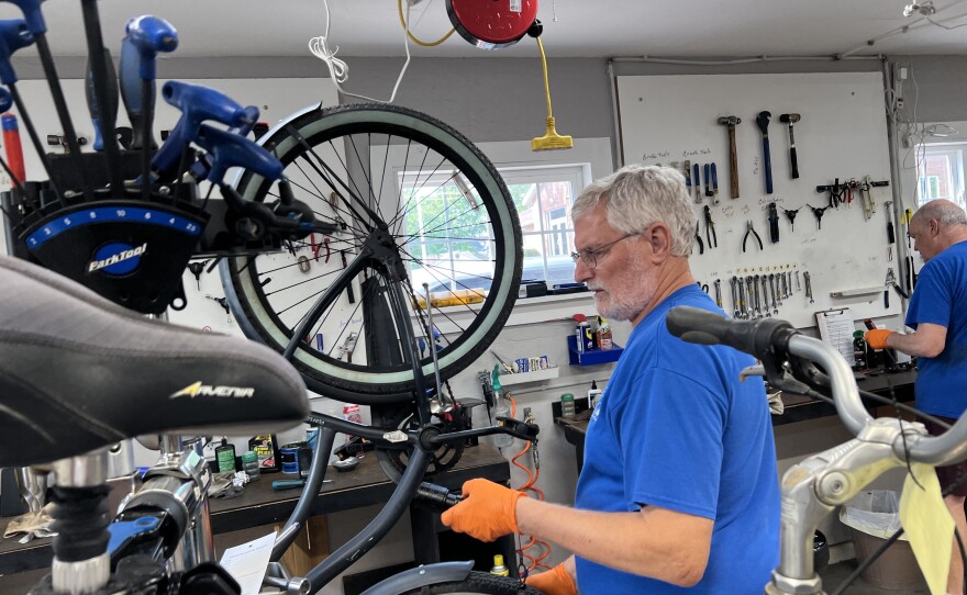 A volunteer at the Wheelhouse mounts a bike on a stand.
