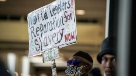 Walter Forster, a Los Angeles resident, holds a sign that advocates for financial compensation during the California Reparations Task Force meeting that was held at the California Science Center in Los Angeles on Sept. 23, 2022.