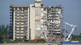 Coast Guard boats patrol in front of the partially collapsed Champlain Towers South condo building in Surfside in July 2021. A judge pushed for compromise on potential payouts between people who lost loved ones and those whose units were destroyed in the deadly collapse of a Florida beachfront condominium.