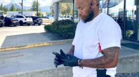 A man stands outside using a cell phone