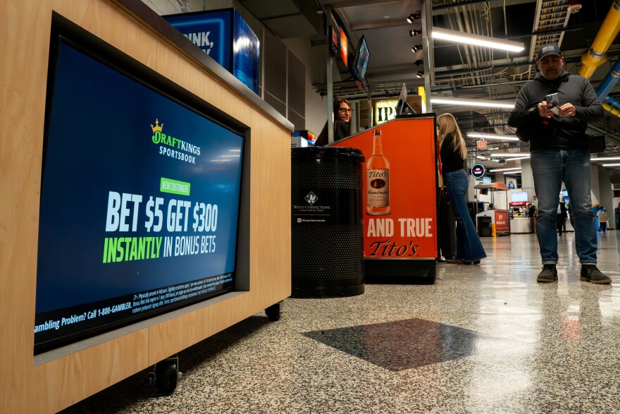 People walk past an advertisement for DraftKings Sportsbook during a matchup between the St. Louis Blues and the Utah Mammoth at the Enterprise Center on Saturday, Nov. 29, 2025 in downtown St. Louis. The St. Louis Blues are among the teams preparing to capitalize on legalized sports betting, which goes live Dec. 1 under a constitutional amendment voters approved last year.