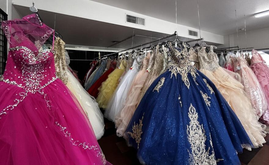 Several racks of colorful gowns and dresses hang in the Azteca Bridal store.