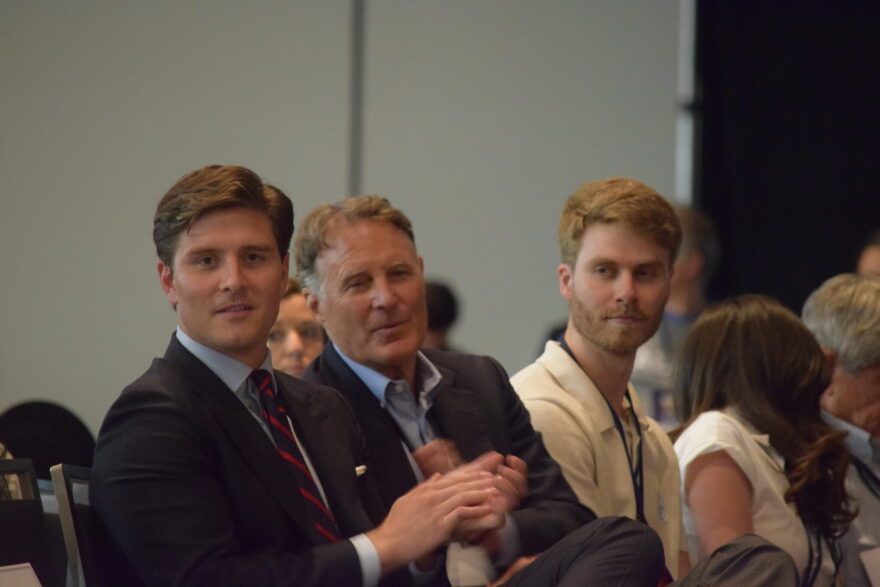Beau Bayh, left, sits next to his father, former governor and U.S. Sen. Evan Bayh, and his brother, Nick, while awaiting voting results during the Indiana Democratic Convention on June 6, 2026, in Indianapolis.