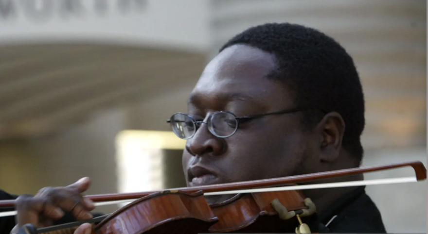 African man with glasses playing violin