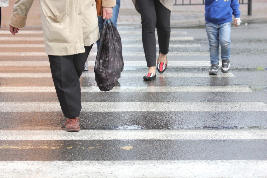 People walk in a crosswalk