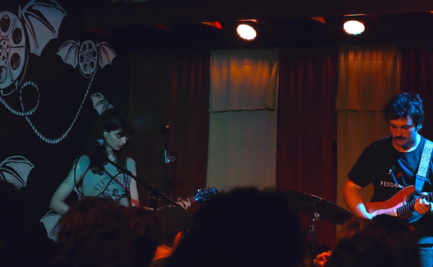 Two musicians perform on stage together.