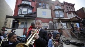 Students play music near the former home, third from left, of jazz musician John Coltrane in Philadelphia. Coltrane lived in a rowhouse in the city's Strawberry Mansion neighborhood from 1952 to 1958. (Matt Rourke/AP)