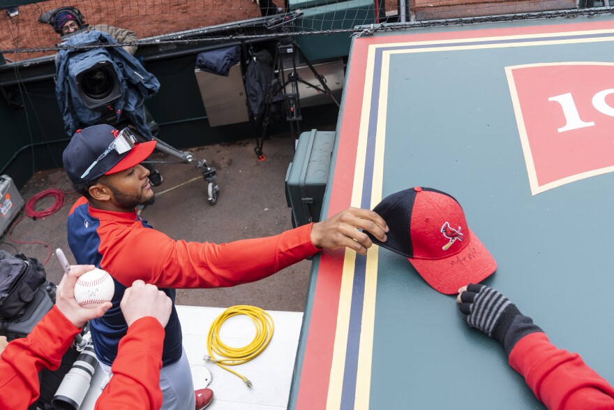 St. Louis Cardinals center fielder Victor Scott II reaches to sign a hat on Thursday before the team’s home opener against the Miami Marlins at Busch Stadium in downtown St. Louis.