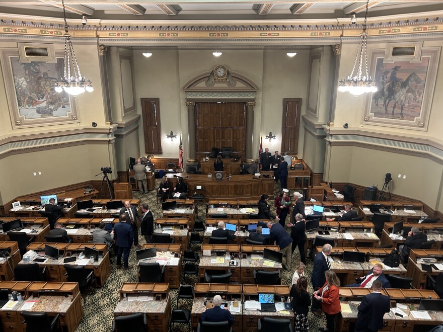 A large hall is filled with long desks in neat rows. At the front is a dais with even bigger desks.