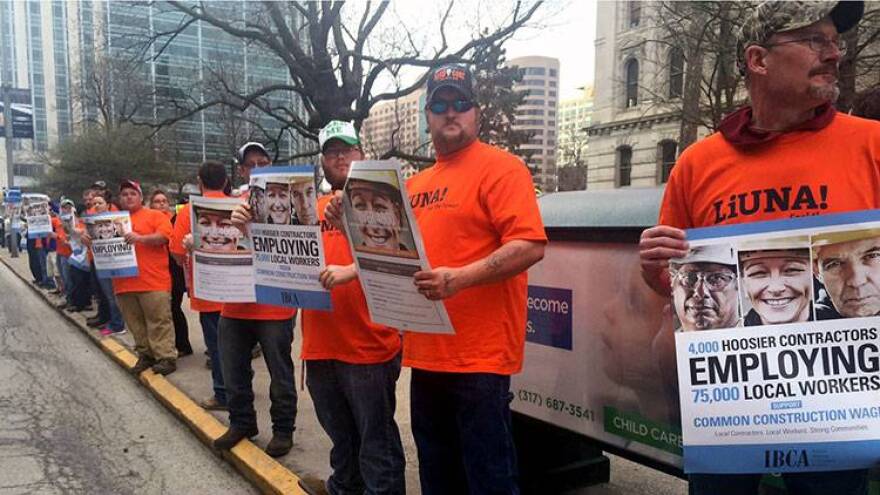 Union workers gathered outside the Statehouse Monday morning ahead of a rally against repeal of the common construction wage.