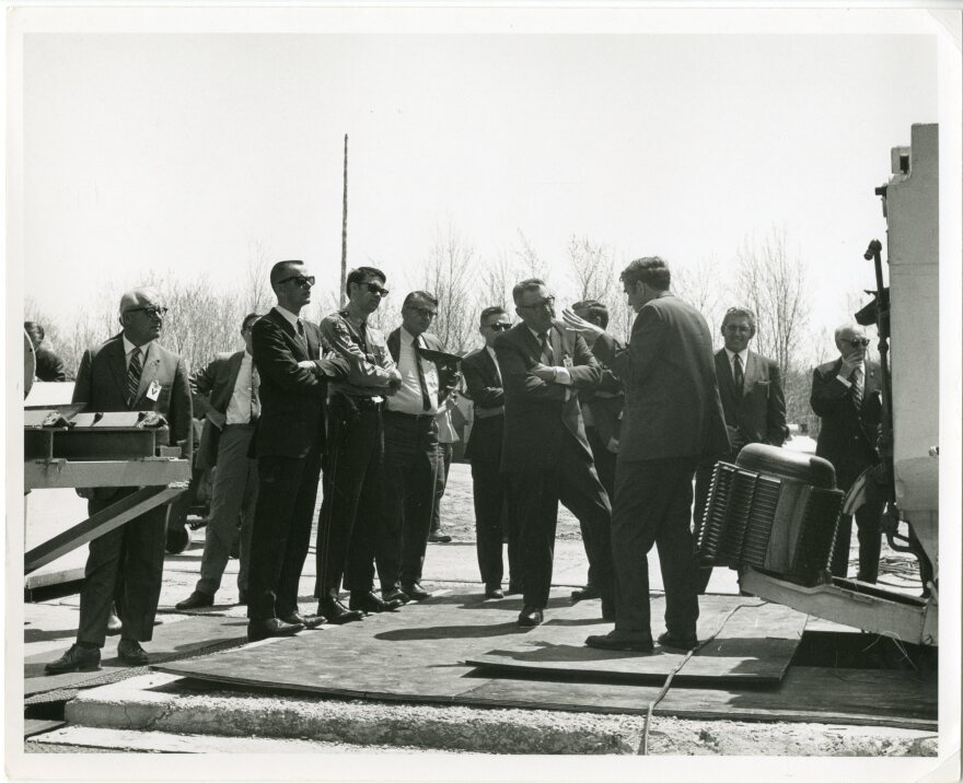 A picture a dozen people standing in a circle
