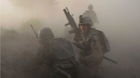 A U.S. Marine and an Afghan soldier react as dust blankets the area after an improvised explosive device exploded while they were under enemy fire on July 17 in Mian Poshteh, Afghanistan.