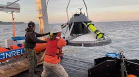Researchers steady a bottom lander, deployed in a tidal study at the East Foreland this summer.