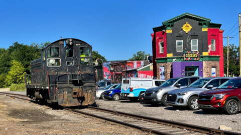 A freight locomotive on the Luzerne County-owned rail line passes South Wilkes-Barre businesses along Horton Street in 2024.