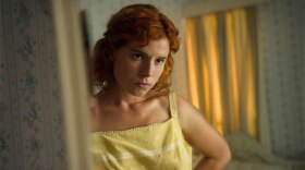 Moll (Jessie Buckley) gets ready to go out in the thriller <em>Beast</em>.