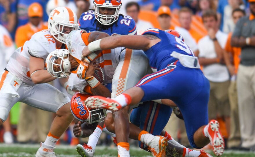 A swarm of Florida defenders tackle Tennessee quarterback Joshua Dobbs (11).