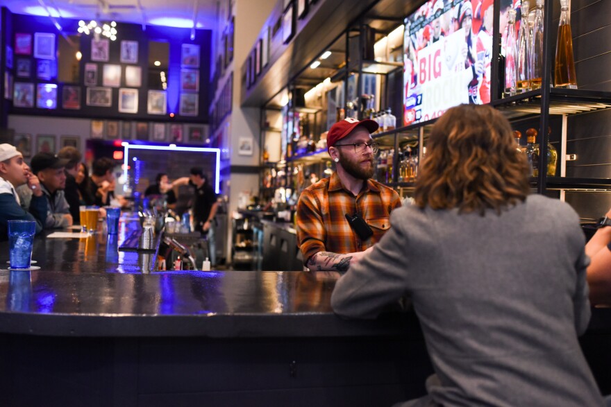 General manager Aaron Orvis spends his shift working as a bartender until he trains more employees.