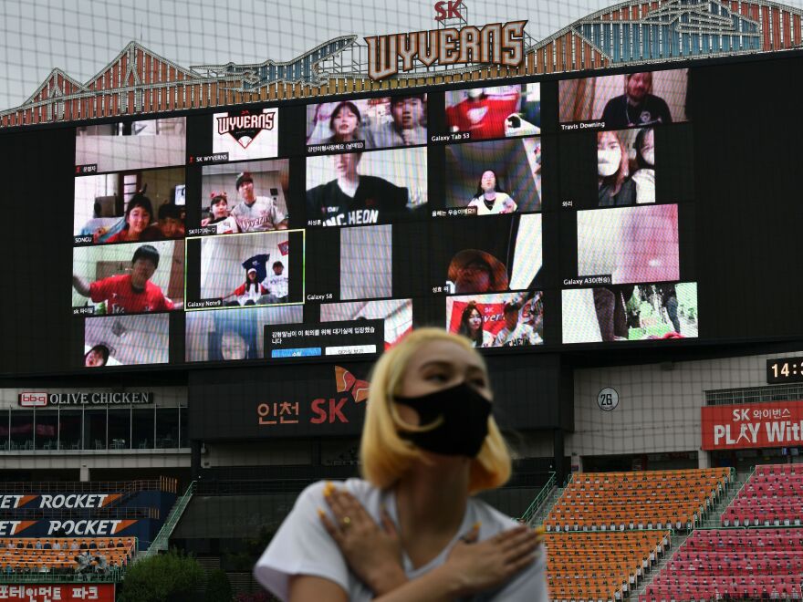 A cheerleader performs in front of a large screen displaying baseball fans cheering from their homes during the opening game of South Korea's new baseball season earlier this month.