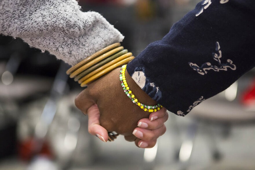 Women hold hands and share their thoughts about the strength of black women at the beginning of a Sister to Sister salon conversation at the Chesterfield in Durham on Friday, October 26, 2018.
