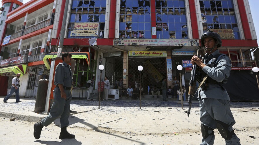 Afghan policemen keep watch at the site of a suicide car bomb attack in Kabul on Aug. 10. Four civilians were killed. It's not clear whether the Afghan security forces will be able to keep the Taliban in check after U.S. and NATO combat forces leave at the end of the year.