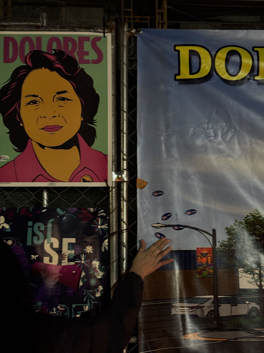 People place "I Voted" stickers near a photo of Dolores Huerta