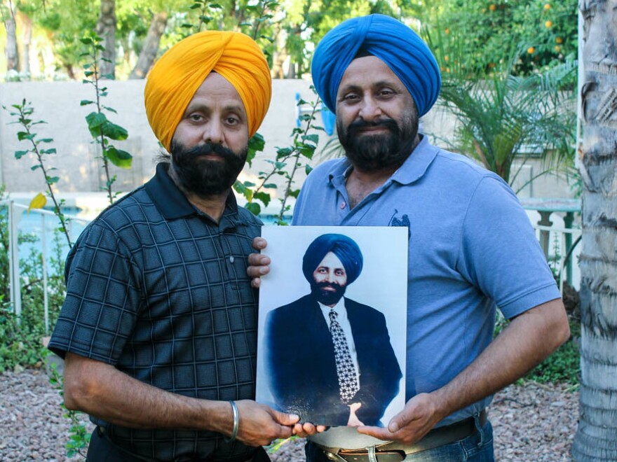 Rana Sodhi (L) and Harjit Sodhi hold a photograph of their late brother, Balbir Singh Sodhi, who was shot and killed at 52. Since his death, the brothers have been involved in educating others about Sikhism and the discrimination their community faces in the U.S.