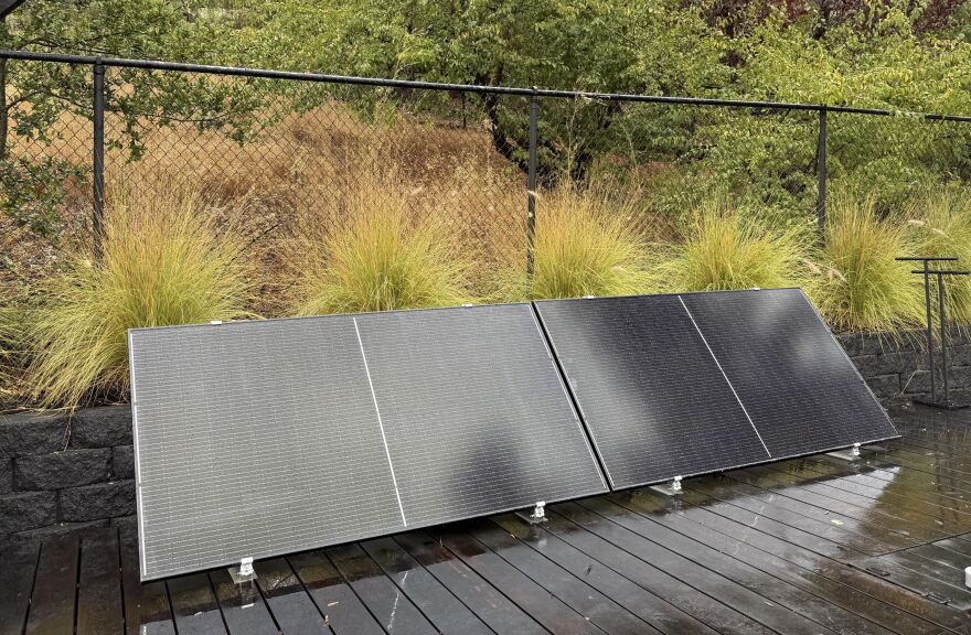 Plug-in solar panels sit on a home's outdoor deck.
