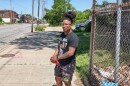 Antoine Tolbert with New Era Cleveland stands on the sidewalk along St. Clair Avenue in Cleveland's Glenville neighborhood.
