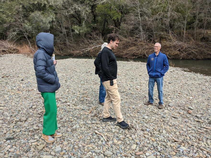 People standing on a rocky beach.