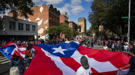 A giant Puerto Rican flag is marched onto Main Street during the Greater Hartford Puerto Rican Day Parade on Sunday Oct. 8, 2023. Thousands marched and gathered along the parade route that finished in Bushnell Park.