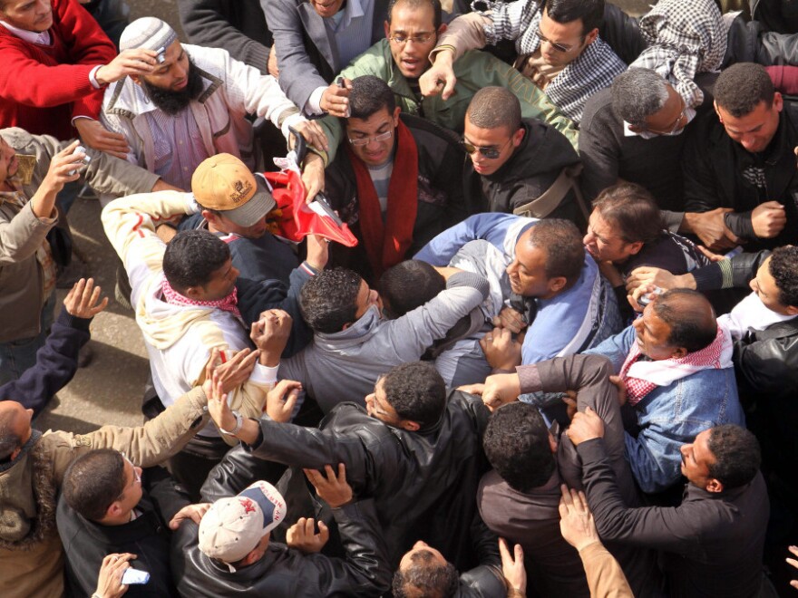 Egyptian protestors opposed to President Hosni Mubarak detain a government supporter during protests near Cairo's central Tahrir square. Some now wonder if past U.S. foreign aid to Egypt could have been handled in a better way to get Cairo moving toward democracy.
