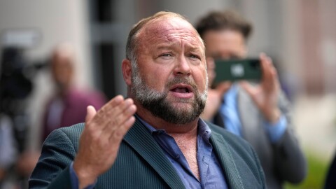 FILE - Right-wing conspiracy theorist Alex Jones speaks to the media after arriving at the federal courthouse for a hearing in front of a bankruptcy judge, June 14, 2024, in Houston.