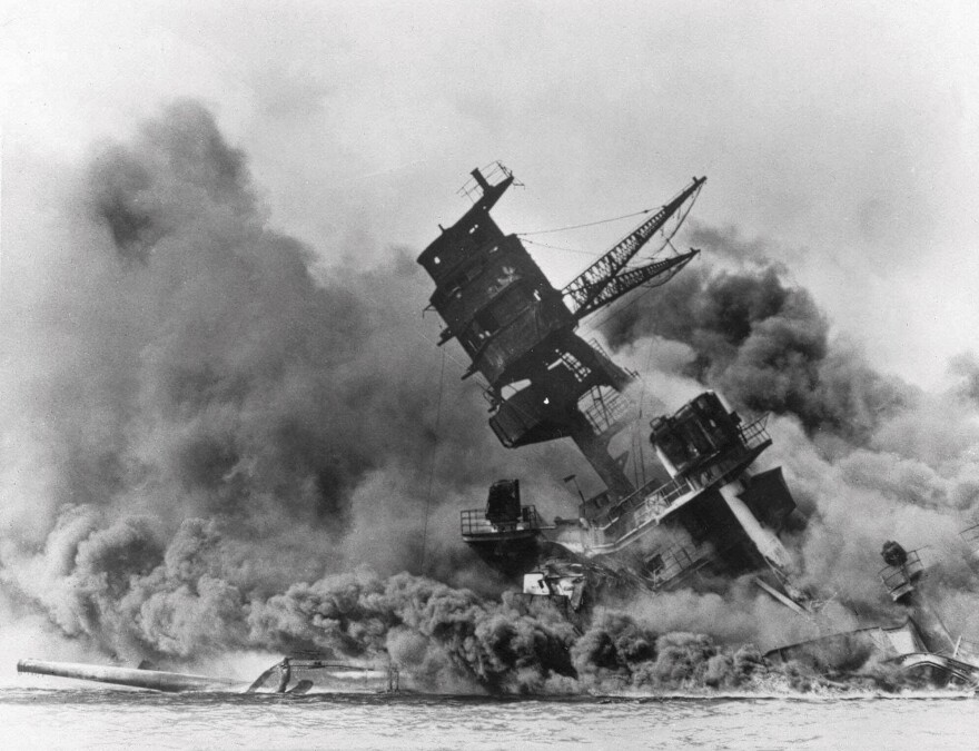 FILE - In this Dec. 7, 1941 file photo, smoke rises from the battleship USS Arizona as it sinks during a Japanese surprise attack on Pearl Harbor, Hawaiʻi. (AP File Photo)